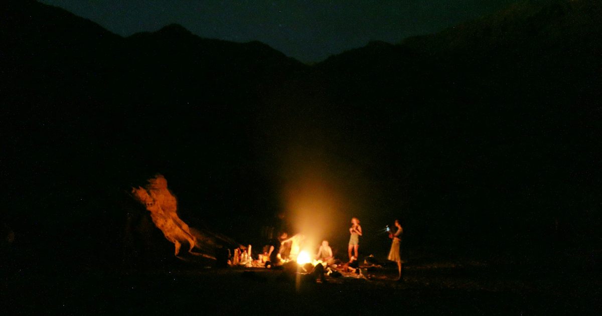 People gathered around a desert campfire at night